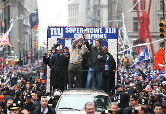 NEW YORK - FEBRUARY 05:  (L-R) Mayor of New York Michael Bloomberg, Michael Strahan and Eli Manning of the New York Giants ride in a float along Broadway, also known as 'The Canyon of Heroes' during Super Bowl XLII victory parade in New York City.  (Photo by Al Bello/Getty Images)