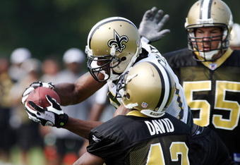JACKSON, MS - AUGUST 1:  Marques Colston #12  catches a ball defended by Scott Fujita #55 and Jason David #42 during the NFL New Orleans Saints training camp August 1, 2007 at Millsaps College in Jackson, Mississippi.   (Photo by Chris Graythen/Getty Images)