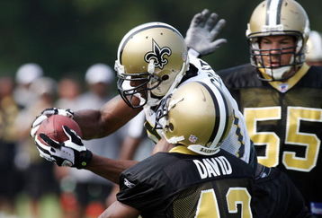JACKSON, MS - AUGUST 1:  Marques Colston #12  catches a ball defended by Scott Fujita #55 and Jason David #42 during the NFL New Orleans Saints training camp August 1, 2007 at Millsaps College in Jackson, Mississippi.   (Photo by Chris Graythen/Getty Images)