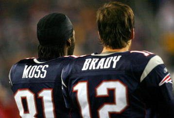 FOXBORO, MA - DECEMBER 23: Randy Moss #81 and Tom Brady #12 of the New England Patriots watch the defense in action against the Miami Dolphins at Gillette Stadium on December 23, 2007 in Foxboro, Massachusetts. Patriots won 28-7. (Photo by Jim Rogash/Getty Images)
