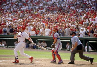 27 Sep 1998:  Mark McGwire #25 of the St. Louis Cardinals hits his 70th home run of the season as catcher Michael Barrett #5 of the Montreal Expos and umpire Rich Rieker watch during a game at the Busch Stadium in St. Louis, Missouri. The Cardinals defeat