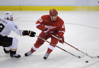 DETROIT - MAY 10:  Johan Franzen #93 of the Detroit Red Wings tries to get around Ryan Whitney #19 of the Anaheim Ducks during Game Five of the Western Conference Semifinals of the 2009 NHL Stanley Cup Playoffs on May 10, 2009 at Joe Louis Arena in Detroit, Michigan.  (Photo by Gregory Shamus/Getty Images)