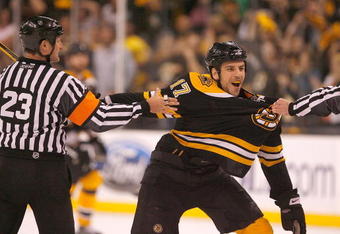 BOSTON - MAY 10: Milan Lucic #17 of the Boston Bruins has to be held back against Carolina Hurricanes the during Game Five of the Eastern Conference Semifinal Round of the 2009 Stanley Cup Playoffs on May 10, 2009 at the TD Banknorth Garden in Boston, Massachusetts. The Bruins won 4-0. (Photo by Jim Rogash/Getty Images)