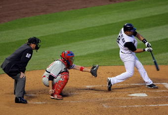 DENVER - APRIL 11:  Catcher Yorvit Torreabla #8 of the Colorado Rockies takes an at bat as catcher Chris Coste #27 of of the Philadelphia Phillies and umpire Gerry Davis look on during MLB action at Coors Field on April 11, 2009 in Denver, Colorado. The Phillies defeated the Rockies 8-4.  (Photo by Doug Pensinger/Getty Images)