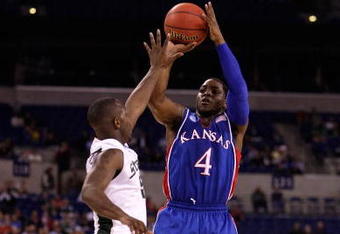 INDIANAPOLIS - MARCH 27:  Sherron Collins #4 of the Kansas Jayhawks attempts a shot against Travis Walton the Michigan State Spartans during the third round of the NCAA Division I Men's Basketball Tournament at the Lucas Oil Stadium on March 27, 2009 in Indianapolis, Indiana.  (Photo by Andy Lyons/Getty Images)