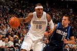 DENVER - MAY 13:  Carmelo Anthony #15 of the Denver Nuggets drives past Jose Juan Barea #11 of the Dallas Mavericks in Game Five of the Western Conference Semifinals during the 2009 NBA Playoffs at Pepsi Center on May 13, 2009 in Denver, Colorado.  The Nuggets defeated the Mavericks 124-110 to advance to the Western Conference Finals.  NOTE TO USER: User expressly acknowledges and agrees that, by downloading and or using this photograph, User is consenting to the terms and conditions of the Getty Images License Agreement.  (Photo by Doug Pensinger/Getty Images)