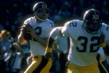 1977:  Quarterback Terry Bradshaw #12 of the Pittsburgh Steelers drops back to pass as teammate Franco Harris #32 runs to get open during a game against the Oakland Raiders at the Oakland Coliseum in Oakland, California. The Raiders defeated the Steelers