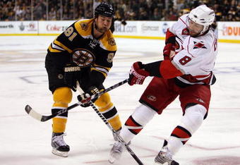 BOSTON - MAY 03:  Marc Savard #91 of the Boston Bruins tries to keep the puck from Matt Cullen #8 of the Carolina Hurricanes during Game Two of the Eastern Conference Semifinal Round of the 2009 Stanley Cup Playoffs on May 3, 2009 at the TD Banknorth Garden in Boston, Massachusetts.  (Photo by Elsa/Getty Images)