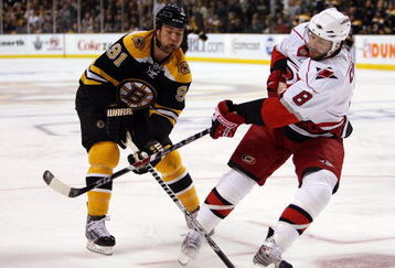 BOSTON - MAY 03:  Marc Savard #91 of the Boston Bruins tries to keep the puck from Matt Cullen #8 of the Carolina Hurricanes during Game Two of the Eastern Conference Semifinal Round of the 2009 Stanley Cup Playoffs on May 3, 2009 at the TD Banknorth Garden in Boston, Massachusetts.  (Photo by Elsa/Getty Images)