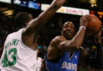 BOSTON - MAY 12:  Dwight Howard #12 of the Orlando Magic drives to the net as Kendrick Perkins #43 of the Boston Celtics defends in Game Five of the Eastern Conference Semifinals during the 2009 NBA Playoffs at TD Banknorth Garden May 12, 2009 in Boston, Massachusetts. The Celtics defeated the Magic 92-88.  NOTE TO USER: User expressly acknowledges and agrees that, by downloading and or using this photograph, User is consenting to the terms and conditions of the Getty Images License Agreement.  (Photo by Elsa/Getty Images)