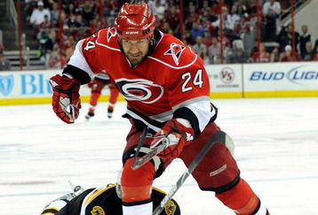 RALEIGH, NC - MAY 12:  Shane Hnidy #34 of the Boston Bruins loses his stick after a hit by Scott Walker #24 of the Carolina Hurricanes in the second period during Game Six of the Eastern Conference Semifinal Round of the 2009 Stanley Cup Playoffs on May 12, 2009 at the RBC Center in Raleigh, North Carolina. (Photo by Grant Halverson/Getty Images)