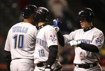 CLEVELAND - APRIL 10: Marco Scutaro #19 of the Toronto Blue Jays celebrates with Aaron Hill  #2 and  Vernon Wells #10 after scoring against the Cleveland Indians in the seventh inning April 10, 2009 at Progressive Field in Cleveland, Ohio.  (Photo by Matt Sullivan/Getty Images)