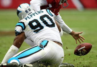 GLENDALE, AZ - OCTOBER 14:  Quarterback Tim Rattay #12 of the Arizona Cardinals recovers his own fumble as he his tackled by defensive end Julius Peppers #90 of the Carolina Panthers at University of Phoenix Stadium October 14, 2007 in Glendale, Arizona. The Panthers won 25-10.  (Photo by Stephen Dunn/Getty Images)