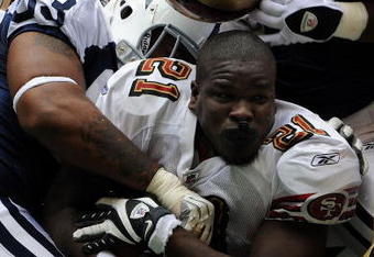 IRVING, TX - NOVEMBER 23:  Running back Frank Gore #21 of the San Francisco 49ers loses his helmet while tackled by Anthony Spencer #93 of the Dallas Cowboys at Texas Stadium on November 23, 2008 in Irving, Texas.  (Photo by Ronald Martinez/Getty Images)