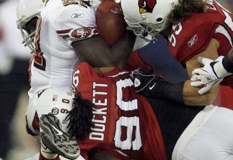 GLENDALE, AZ - NOVEMBER 10:  Frank Gore #21 of the San Francisco 49ers is stopped by Darnell Dockett #90 and Travis LaBoy #55 of the Arizona Cardinals during the third quarter at University of Phoenix Stadium on November, 10 2008 in Glendale, Arizona.  (Photo by Harry How/Getty Images)