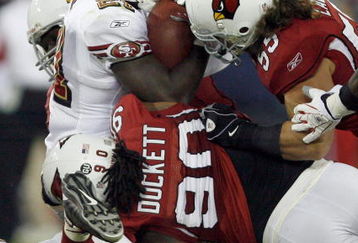GLENDALE, AZ - NOVEMBER 10:  Frank Gore #21 of the San Francisco 49ers is stopped by Darnell Dockett #90 and Travis LaBoy #55 of the Arizona Cardinals during the third quarter at University of Phoenix Stadium on November, 10 2008 in Glendale, Arizona.  (Photo by Harry How/Getty Images)