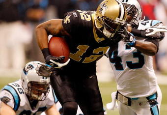 NEW ORLEANS - DECEMBER 28:  Marques Colston #12 of the New Orleans Saints avoids a tackle to score a touchdown around Chris Harris #43 of the Carolina Panthers on December 28, 2008 at the Superdome in New Orleans, Louisiana.  (Photo by Chris Graythen/Getty Images)