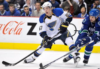 VANCOUVER, CANADA - APRIL 15: David Perron #57 of the St. Louis Blues takes a shot on the Vancouver Canucks goal while being checked by Willie Mitchell #8 of the Vancouver Canucks during Game One of the Western Conference Quarterfinals of the 2009 Stanley Cup Playoffs at General Motors Place on April 15, 2009 in Vancouver, British Columbia, Canada.  (Photo by Nick Didlick/Getty Images)