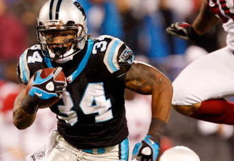 CHARLOTTE, NC - JANUARY 10:  DeAngelo Williams #34 of the Carolina Panthers runs the ball while Bryan Robinson #97 of the Arizona Cardinals looks on during the NFC Divisional Playoff Game on January 10, 2009 at Bank of America Stadium in Charlotte, North Carolina.  (Photo by Streeter Lecka/Getty Images)
