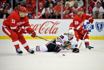 DETROIT - MAY 17:  Patrick Kane #88 of the Chicago Blackhawks reachs for the puck against Valtteri Filppula #51 and Brian Rafalski #28 of the Detroit Red Wings during Game One of the Western Conference Championship Round of the 2009 Stanley Cup Playoffs on May 17, 2009 at Joe Louis Arena in Detroit, Michigan. The Red WIngs won 5-2.  (Photo by Jamie Sabau/Getty Images)