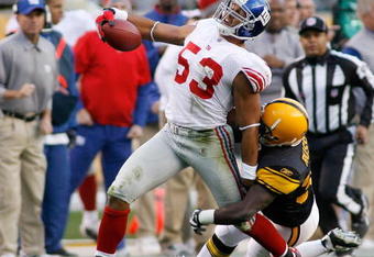 PITTSBURGH - OCTOBER 26: Bryan Kehl #53 of the New York Giants is tackled by Gary Russell #33 of the Pittsburgh Steelers after Kehl intercepted a pass on October 26, 2008 at Heinz Field in Pittsburgh, Pennsylvania. Russell was called for a horsecollar penalty on the play. (Photo by Rick Stewart/Getty Images)