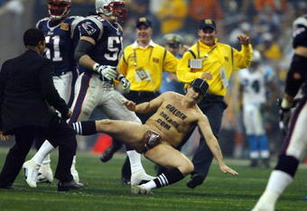 HOUSTON - FEBRUARY 1:  A fan falls on the field as security officials try to apprehend him during a break in Super Bowl XXXVIII game action between the New England Patriots and the Carolina Panthers at Reliant Stadium on February 1, 2004 in Houston, Texas.  The Patriots defeated the Panthers 32-29.  (Photo by Andy Lyons/Getty Images)