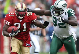 SAN FRANCISCO - DECEMBER 07:  Frank Gore #21 of the San Francisco 49ers runs against Shaun Ellis #92 of the New York Jets during an NFL game on December 7, 2008 at Candlestick Park in San Francisco, California.  (Photo by Jed Jacobsohn/Getty Images)