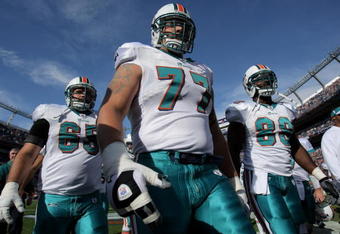 DENVER - NOVEMBER 02:  Guard Justin Smiley #65, tackle Jake Long #77 and tight end David Martin #88 of the Miami Dolphins leave the field after warming up prior to facing the Denver Broncos during NFL action at Invesco Field at Mile High on November 2, 2008 in Denver, Colorado. The Dolphins defeated the Broncos 26-17.  (Photo by Doug Pensinger/Getty Images)
