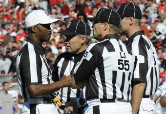 TAMPA, FL - NOVEMBER 16: NFL referee Mike Carey (white cap) reviews a play as the Tampa Bay Buccaneers host the Minnesota Vikings at Raymond James Stadium on November 16, 2008 in Tampa, Florida.  (Photo by Al Messerschmidt/Getty Images) 