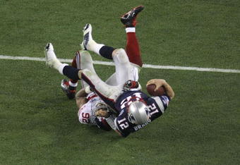 GLENDALE, AZ - FEBRUARY 03:  Quarterback Tom Brady #12 of the New England Patriots lies on his back after being sacked by defensive end Michael Strahan #92 of the New York Giants in the third quarter during Super Bowl XLII on February 3, 2008 at the University of Phoenix Stadium in Glendale, Arizona.  (Photo by Doug Pensinger/Getty Images)