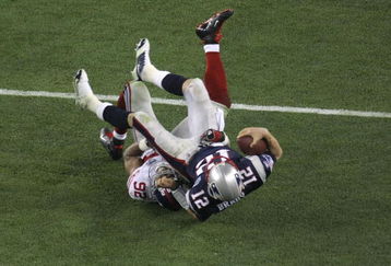 GLENDALE, AZ - FEBRUARY 03:  Quarterback Tom Brady #12 of the New England Patriots lies on his back after being sacked by defensive end Michael Strahan #92 of the New York Giants in the third quarter during Super Bowl XLII on February 3, 2008 at the University of Phoenix Stadium in Glendale, Arizona.  (Photo by Doug Pensinger/Getty Images)