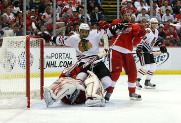 DETROIT - MAY 19:  Dustin Byfuglien #33 of the Chicago Blackhawks falls down in the crease as he got tied up with goalie Chris Osgood #30 and Niklas Kronwall #55 (R) of the Detroit Red Wings during Game Two of the Western Conference Championship Round of the 2009 Stanley Cup Playoffs on May 19, 2009 at Joe Louis Arena in Detroit, Michigan.  (Photo by Dave Sandford/Getty Images)