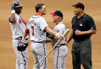 NEW YORK - SEPTEMBER 06:  First base coach Glenn Hubbard of the Atlanta Braves gets between Jeff Francoeur #7 and umpire Kerwin Danley as Francoeur argues after being called out on fan interference against the New York Mets as Edgar Renteria #11 looks on on September 6, 2006 during the second game of their doubleheader at Shea Stadium in the Flushing neighborhood of the Queens borough of New York City.   (Photo by Jim McIsaac/Getty Images)