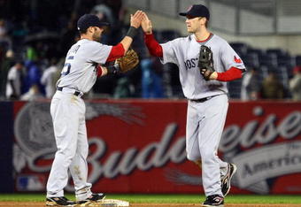 NEW YORK - MAY 05:  Dustin Pedroia #15 and Jason Bay #44 of the Boston Red Sox celebrate after the final out of the game against the New York Yankees on May 5, 2009 at Yankee Stadium in the Bronx borough of New York City. The Red Sox defeated the Yankees 7-3.  (Photo by Jim McIsaac/Getty Images)