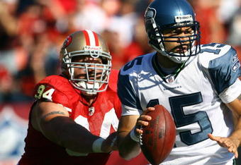 SAN FRANCISCO - OCTOBER 26:  Quarterback Seneca Wallace #15 of the Seattle Seahawks drops back to pass while being pursued by Justin Smith #94 of the San Francisco 49ers in the second quarter at Candlestick Park on October 26, 2008 in San Francisco, California. The Seahawks defeated the 49ers 34-13.  (Photo by Jeff Gross/Getty Images)
