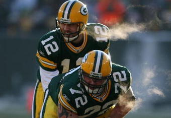 GREEN BAY, WI - DECEMBER 28: Aaron Rodgers #12 of the Green Bay Packers awaits the snap from George Foster #72 during a game against the Detroit Lions on December 28, 2008 at Lambeau Field in Green Bay, Wisconsin. The Packers defeated the Lions 31-21.  (Photo by Jonathan Daniel/Getty Images)
