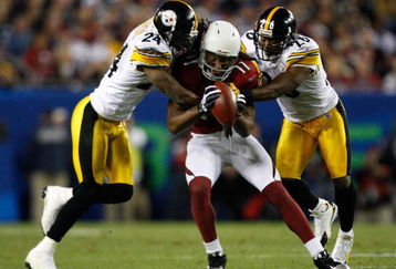 TAMPA, FL - FEBRUARY 01:  Wide receiver Larry Fitzgerald #11 of the Arizona Cardinals makes a reception in the fourth quarter against Ike Taylor #24 and Deshea Townsend #26 of the Pittsburgh Steelers during Super Bowl XLIII on February 1, 2009 at Raymond James Stadium in Tampa, Florida.  (Photo by Streeter Lecka/Getty Images)