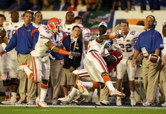 MIAMI - JANUARY 08:  Manuel Johnson #1 of the Oklahoma Sooners can't make a catch along the sideline as he is hit by Major Wright #21 of the Florida Gators during the FedEx BCS National Championship game at Dolphin Stadium on January 8, 2009 in Miami, Florida. Joe Haden #5 of the Gators trails on the play. FLorida won 24-14.  (Photo by Doug Benc/Getty Images)