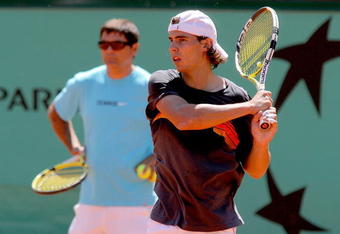 PARIS - MAY 22:  ATP World Tour number one ranked player Rafael Nadal of Spain practices while his uncle and coach Toni Nadal watches from behind in preparation for the French Open at Roland Garros on May 22, 2009 in Paris, France.  (Photo by Matthew Stockman/Getty Images)