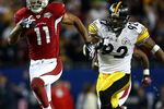 TAMPA, FL - FEBRUARY 01:  Larry Fitzgerald #11 of the Arizona Cardinals runs for a touchdown after a catch against James Harrison #92 of the Pittsburgh Steelers in the fourth quarter during Super Bowl XLIII on February 1, 2009 at Raymond James Stadium in Tampa, Florida.  (Photo by Chris McGrath/Getty Images)