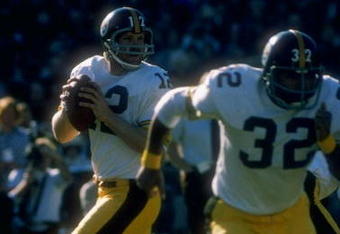 1977:  Quarterback Terry Bradshaw #12 of the Pittsburgh Steelers drops back to pass as teammate Franco Harris #32 runs to get open during a game against the Oakland Raiders at the Oakland Coliseum in Oakland, California. The Raiders defeated the Steelers