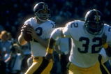1977:  Quarterback Terry Bradshaw #12 of the Pittsburgh Steelers drops back to pass as teammate Franco Harris #32 runs to get open during a game against the Oakland Raiders at the Oakland Coliseum in Oakland, California. The Raiders defeated the Steelers