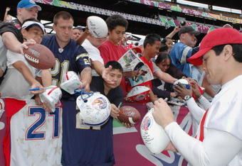 Football fans seek an autograph from New England Patriots linebacker Tedy Bruschi after  an AFC squad practice for the 2005 Pro Bowl at Aloha Stadium, Honolulu February 12, 2005.  (Photo by Al Messerschmidt/Getty Images)