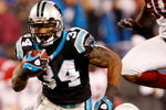 CHARLOTTE, NC - JANUARY 10:  DeAngelo Williams #34 of the Carolina Panthers runs the ball while Bryan Robinson #97 of the Arizona Cardinals looks on during the NFC Divisional Playoff Game on January 10, 2009 at Bank of America Stadium in Charlotte, North Carolina.  (Photo by Streeter Lecka/Getty Images)