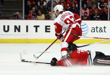 CHICAGO - MAY 24:  Johan Franzen #93 of the Detroit Red Wings skates with the puck as Brent Seabrook #7 the Chicago Blackhawks slides head first down the ice behind him during Game Four of the Western Conference Championship Round of the 2009 Stanley Cup Playoffs on May 24, 2009 at the United Center in Chicago, Illinois.  (Photo by Jonathan Daniel/Getty Images)