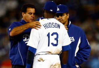 LOS ANGELES, CA - MAY 19:  Orlando Hudson #13 of the Los Angeles Dodgers is attended to by a trainer (L) after suffering an injury as Manager Joe Torre looks on against the New York Mets in the seventh inning at Dodger Stadium on May 19, 2009 in Los Angeles, California.  (Photo by Jeff Gross/Getty Images)