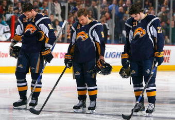 BUFFALO, NY - FEBRUARY 13: Craig Rivet #52, Derek Roy #9 and Drew Stafford #21 of the Buffalo Sabres pause for a moment of silence for the victims of Continental Connection flight 3407 prior to playing the San Jose Sharks  on February 13, 2009 at HSBC Arena in Buffalo, New York. The flight crashed in the Buffalo suburb of Clarence Center on Feb 12, 2009.  (Photo by Rick Stewart/Getty Images)