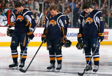 BUFFALO, NY - FEBRUARY 13: Craig Rivet #52, Derek Roy #9 and Drew Stafford #21 of the Buffalo Sabres pause for a moment of silence for the victims of Continental Connection flight 3407 prior to playing the San Jose Sharks  on February 13, 2009 at HSBC Arena in Buffalo, New York. The flight crashed in the Buffalo suburb of Clarence Center on Feb 12, 2009.  (Photo by Rick Stewart/Getty Images)
