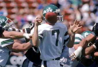 LOS ANGELES, CA - SEPTEMBER 8:  Quarterback Ken O'Brien #7 of the New York Jets has the ball knocked loose during a game against the Los Angeles Raiders at the Los Angeles Memorial Coliseum on September 8, 1985 in Los Angeles, California.  The Raiders won 31-0  (Photo by George Rose/Getty Images)
