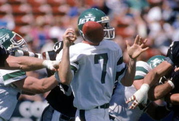 LOS ANGELES, CA - SEPTEMBER 8:  Quarterback Ken O'Brien #7 of the New York Jets has the ball knocked loose during a game against the Los Angeles Raiders at the Los Angeles Memorial Coliseum on September 8, 1985 in Los Angeles, California.  The Raiders won 31-0  (Photo by George Rose/Getty Images)